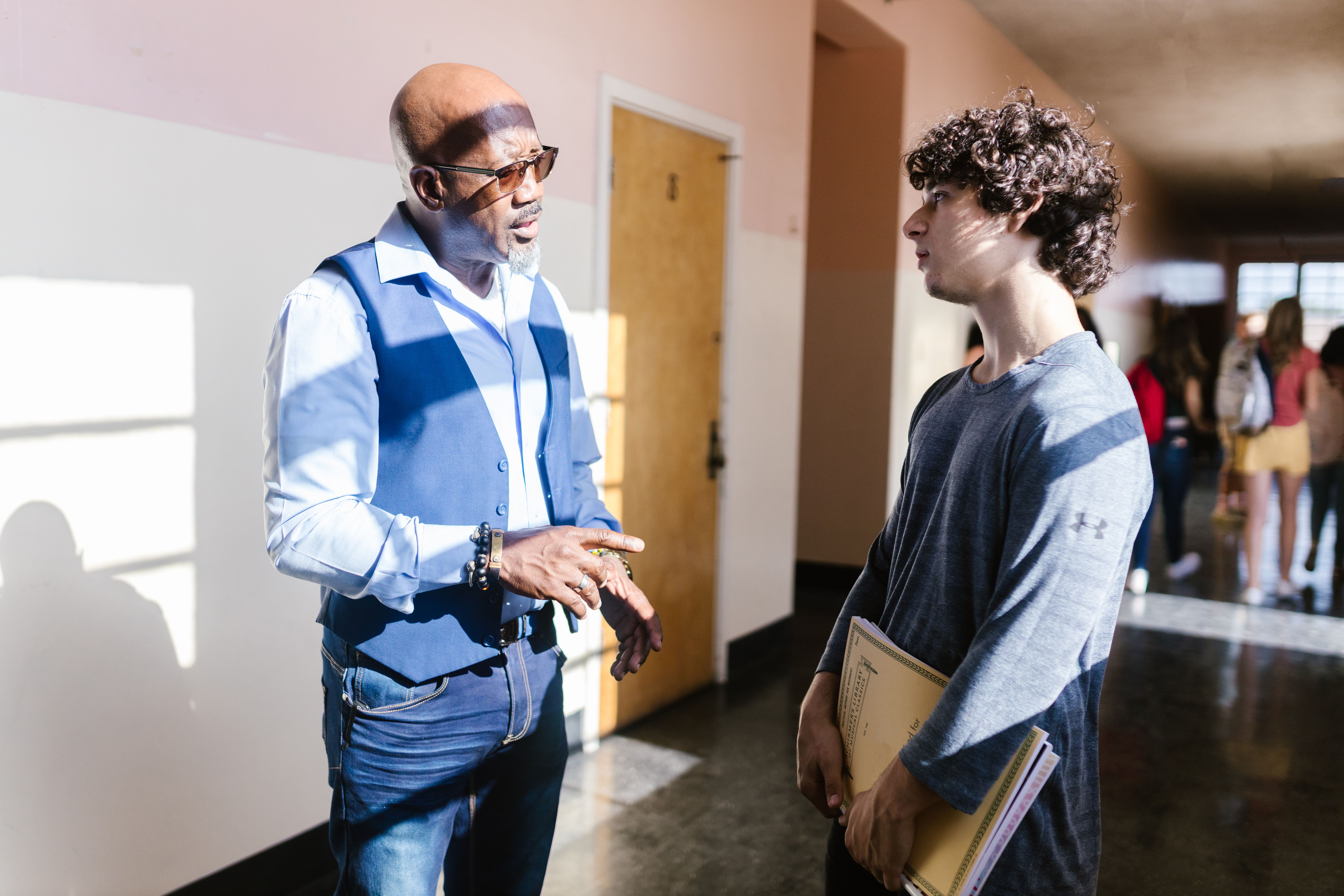 Teacher speaking with student in hallway